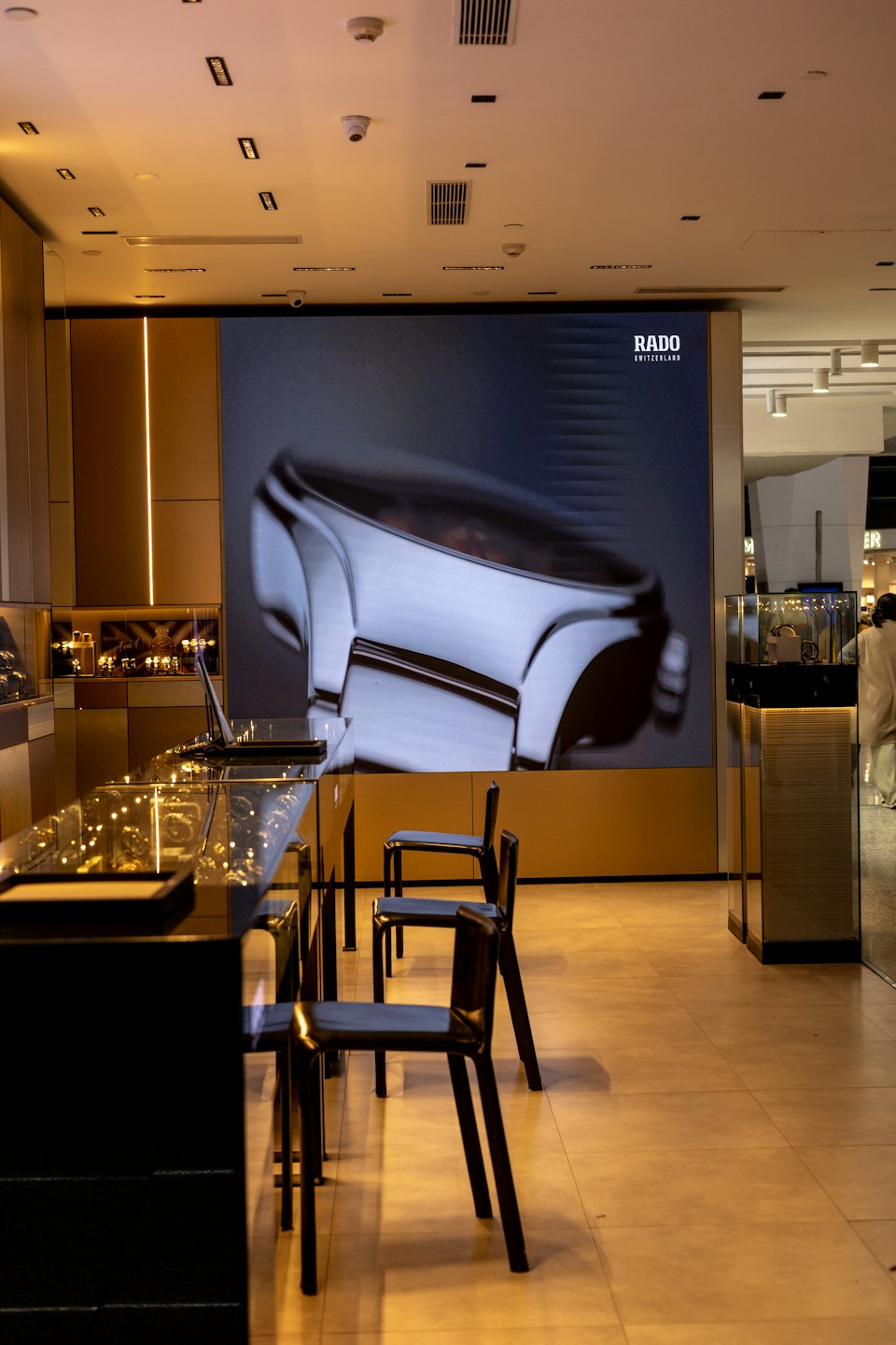 Boutique di gioielli moderna con espositori illuminati per orologi e grandi pubblicità.